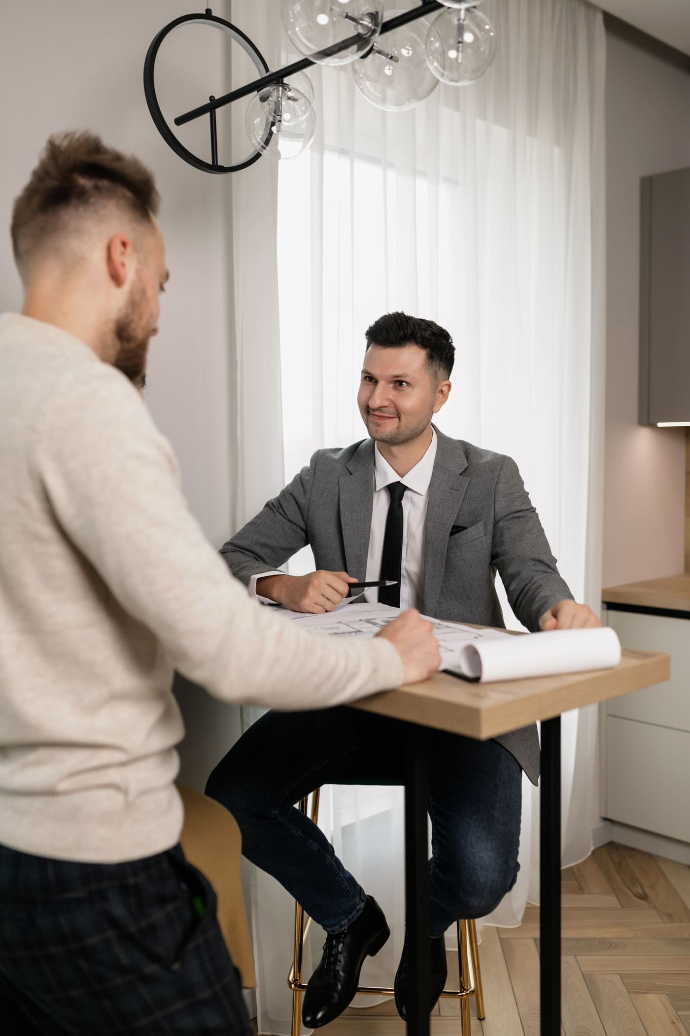 An agent talking a client through floor plans in a bright interior