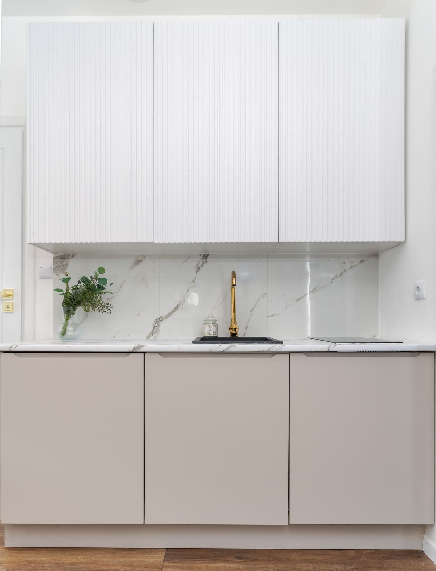 Veined marble splashback with a brushed brass tap
