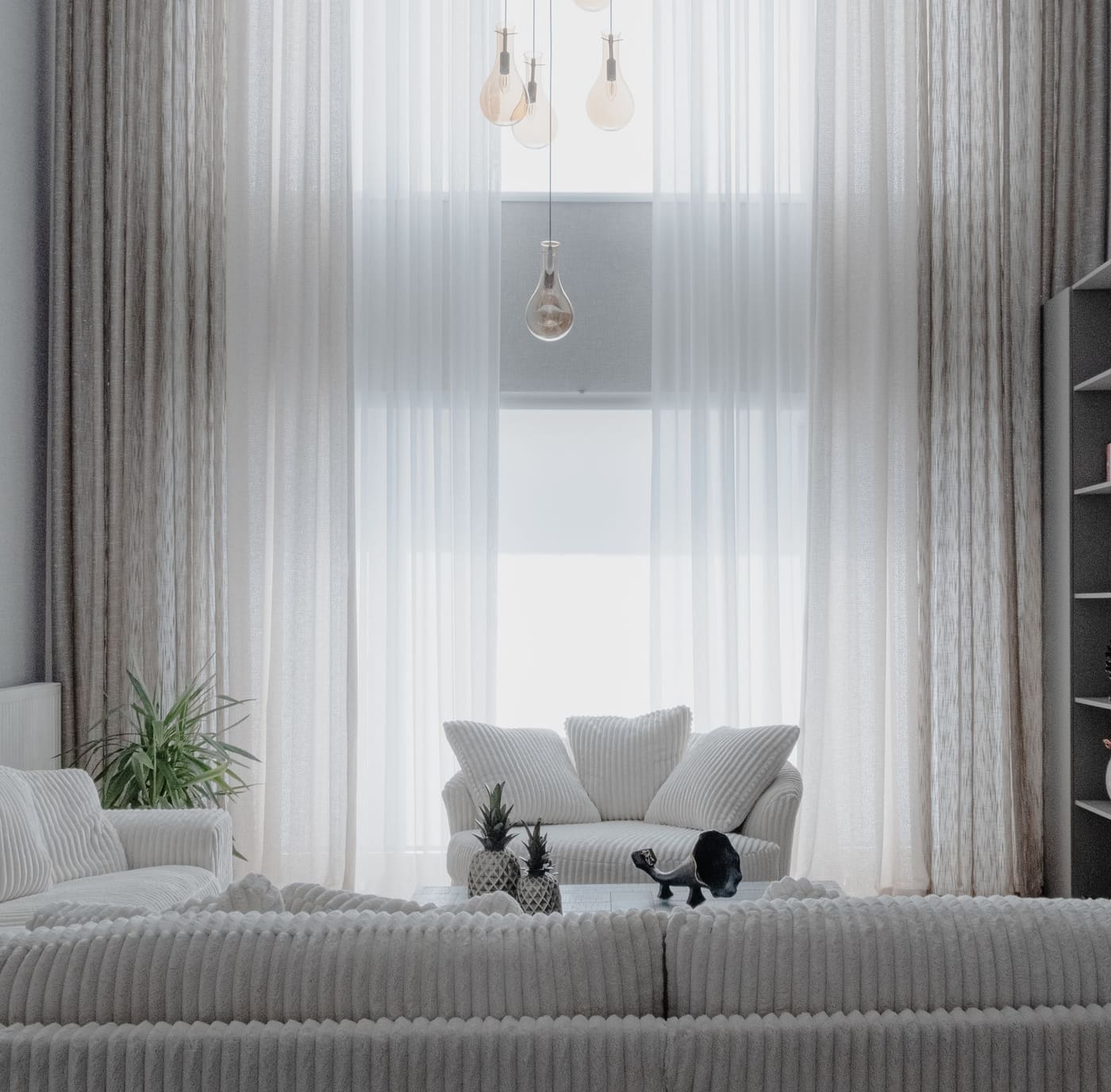 A serene double-height living room with sheer floor-to-ceiling curtains