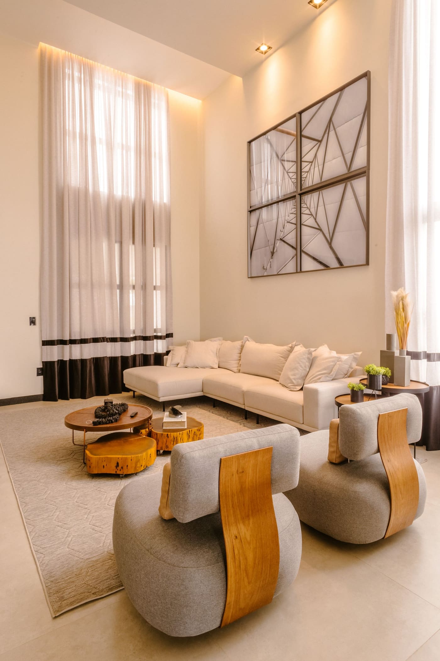 A tall, light-filled living room in soft neutral tones