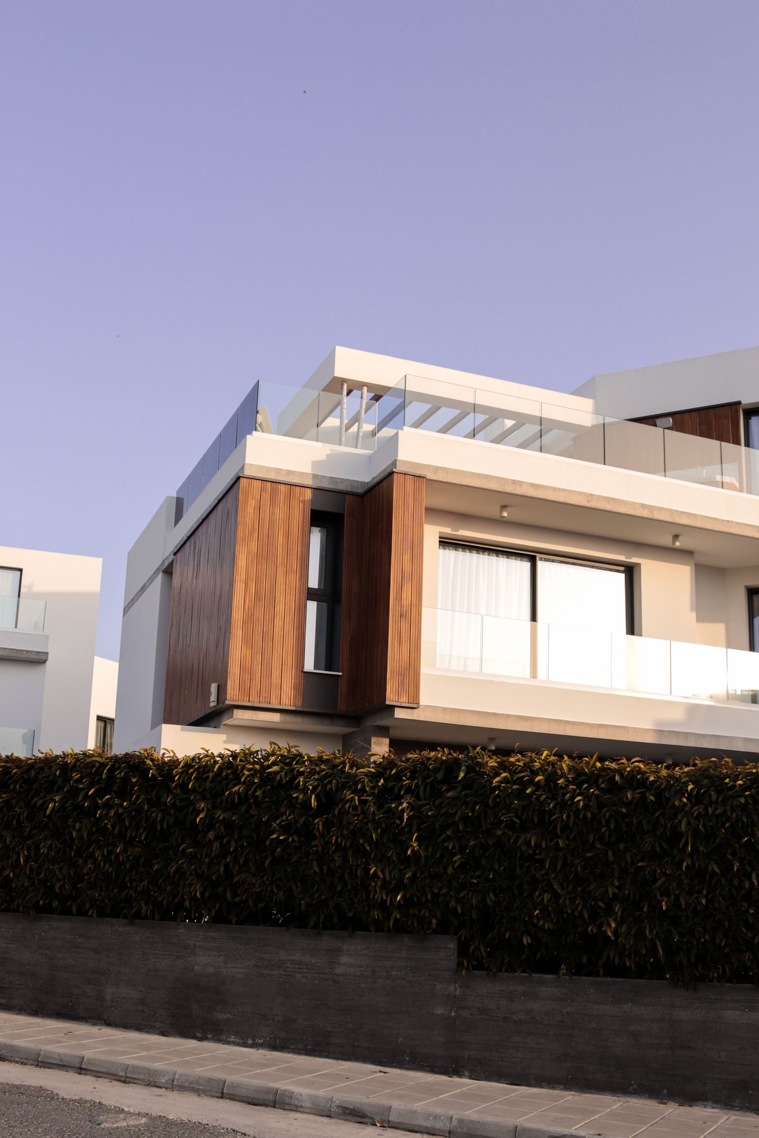 A contemporary white and timber villa against a soft evening sky